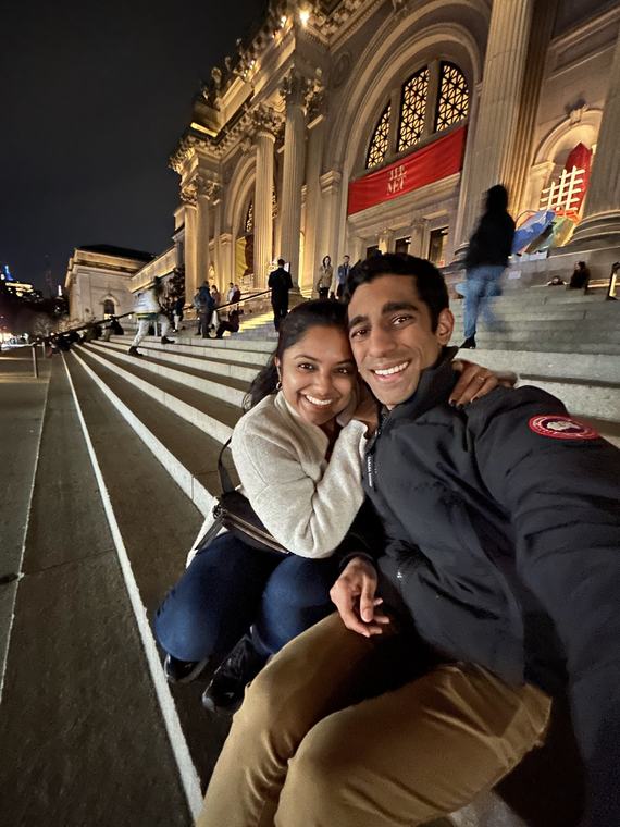 Manu and Nikhil on the steps of the Met at night